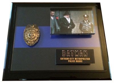 Gotham City Metropolitan Police Badge 
This police badge was worn by a Gotham City Police Department Officer in the 1989 motion picture "Batman", starring Michael Keaton and Jack Nicholson. The badge was custom made for the film out of a cast metal then brushed with bronze and gold. The badge has lettering which reads, â€œMetropolitan Police; To serve and Protect; 1069â€.This badge can be seen worn by G.C.P.D. characters in several sequences from the film, most noticeably by two officers outside the courthouse when Harvey Dent exits with Gotham officials. Through the film, many badges are seen but in this courthouse exterior we can clearly see these badges are gold. 
Keywords: Gotham City Metropolitan Police Badge 