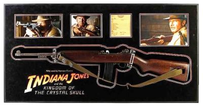 Indiana Jones' (Harrison Ford) Hero M1 Carbine Rifle
Few action heroes have captured the worldâ€™s imagination like Indiana Jones (Harrison Ford)  in the blockbuster action movie franchise. This is â€œIndyâ€™sâ€ hero M1 Carbine Rifle used in the 2008 Steven Spielberg sequel, Indiana Jones and the Kingdom of the Crystal Skull. The rifle is visible early in the film when Indy uses his famous whip to steal the rifle from the hands of Russian soldier. He then uses the rifle to threaten Spalko (Kate Blanchett), before giving up. This authentic M1 Carbine rifle features a dark polished wood stock, metal barrel, bolt and trigger and retains its screen-used green shoulder strap. The ammo magazine is a cast rubber replica that replaced its 30 round magazine. The rifle has impeccable provenance and can be screen matched down to the marks in the wood-grain. Included are the original production rental agreements, as well as the on-set armorerâ€™s sign-out card for the day, which lists the serial number of the rifle and is annotated â€œHFâ€ for use by Harrison Ford. 
Keywords: Indiana Jones' (Harrison Ford) Hero M1 Carbine Rifle