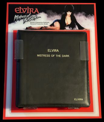 Elvira's Production Used Annotated Binder
Elvira's production used binder for the 1988 feature film, Elvira: Mistress of the Dark, annotated in Cassandra Peterson's hand. Binder includes extensive coverage of the production of the film, including production memos about cuts made for budgetary reasons; cast lists and annotated audition information; oneline rehearsal schedule; oneline shoot schedule; oneline continuity; a lengthy section on the film's final Las Vegas musical number, including final and alternate lyrics for the song "Here I Am," lyrics for other unused songs, photocopies of costume and set sketches by Jerry Jackson, and a highlighted and annotated revised shooting script dated December 23, 1987. Along with the script, a thank you card to Elvira with notes and signatures from the film's crew and a coffin shaped invitation to a gala screening of the film was also obtained directly from the collection of Cassandra Peterson.
Keywords: Elvira's Production Used Annotated Binder